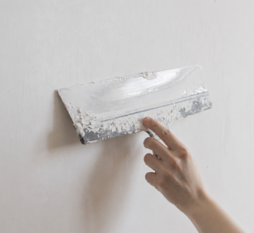 Plasterer skimming and preparing a wall before painting in Milton Keynes